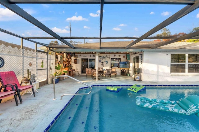 view of swimming pool featuring a lanai and a patio