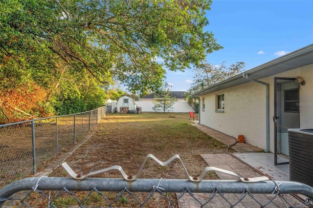 view of yard with central AC unit and a shed