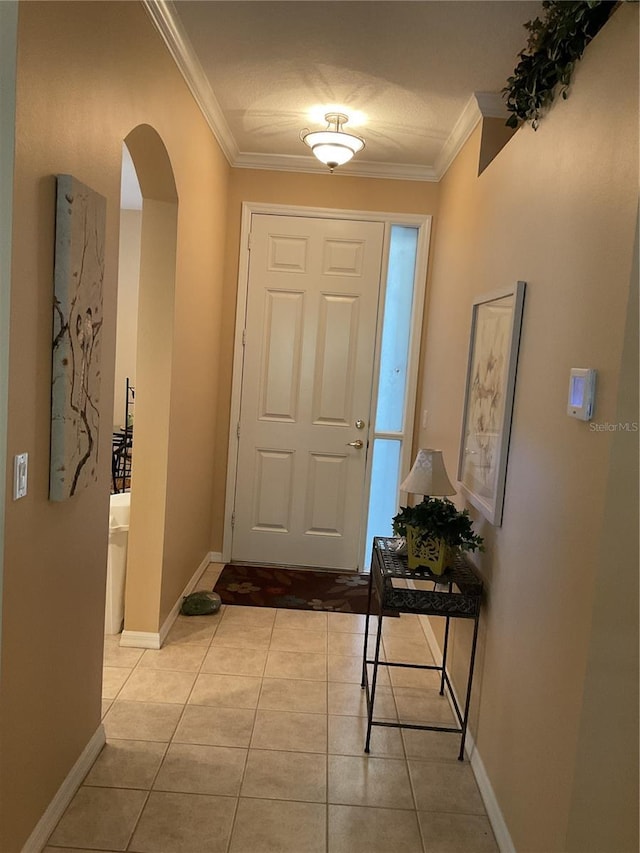 tiled foyer entrance featuring a textured ceiling and crown molding