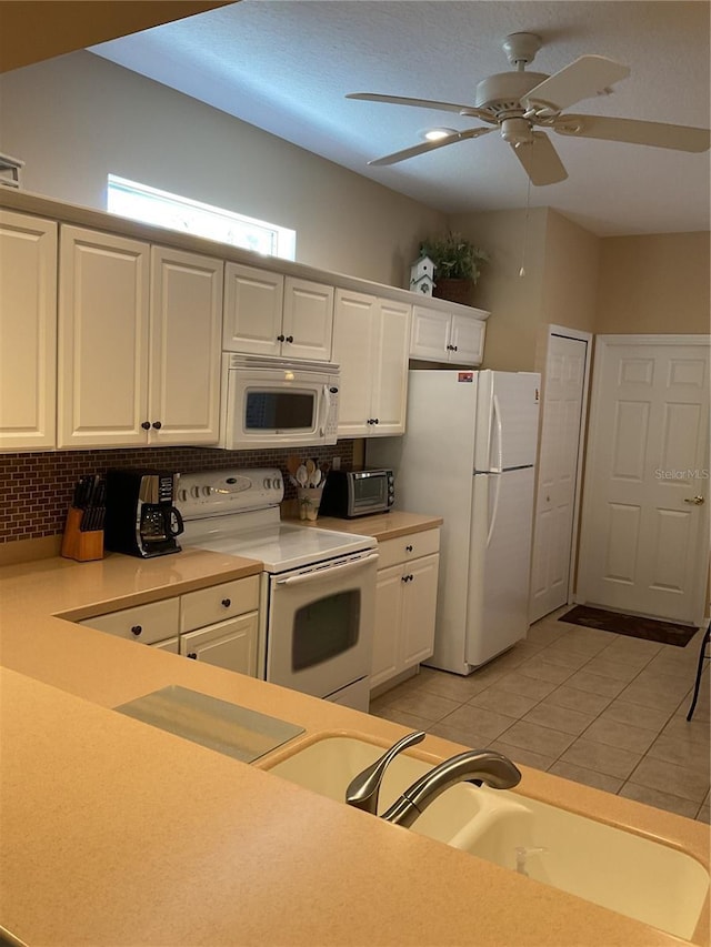 kitchen with decorative backsplash, white appliances, ceiling fan, light tile patterned floors, and white cabinetry