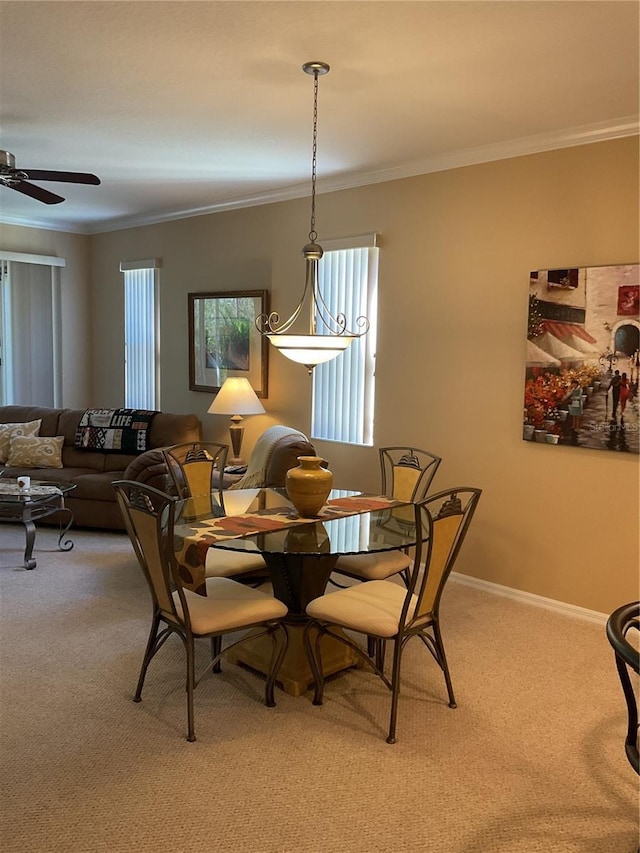 dining space with ceiling fan, carpet floors, and ornamental molding