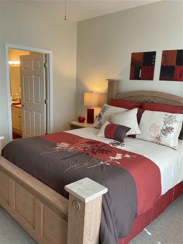 bedroom featuring ensuite bath and light carpet