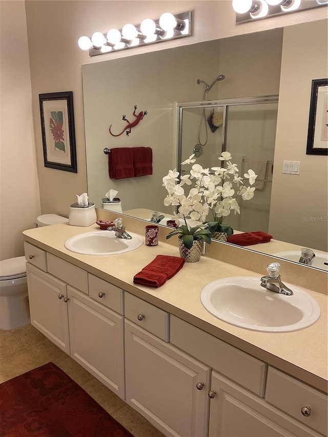 bathroom with tile patterned flooring, vanity, toilet, and an enclosed shower