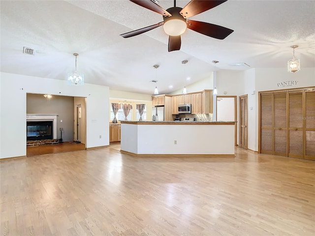 unfurnished living room with a textured ceiling, ceiling fan with notable chandelier, light hardwood / wood-style flooring, and lofted ceiling