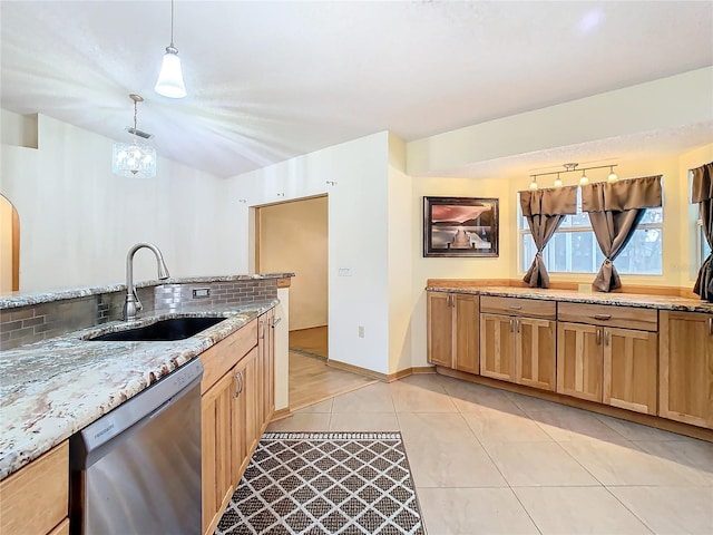 kitchen with dishwasher, sink, hanging light fixtures, tasteful backsplash, and light stone counters