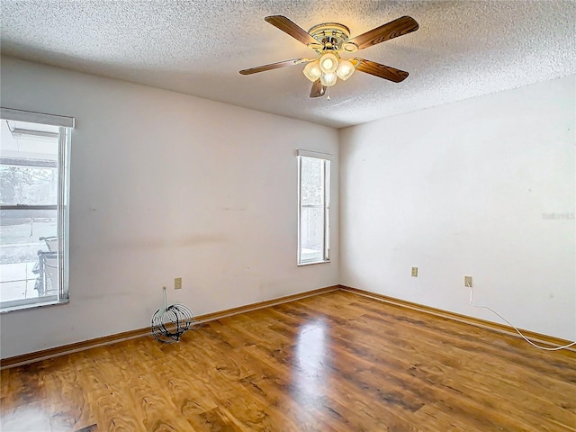 unfurnished room with hardwood / wood-style floors, a healthy amount of sunlight, and a textured ceiling