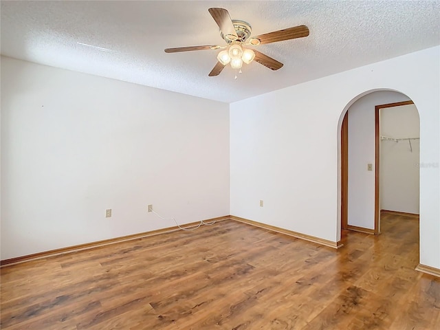 unfurnished room with hardwood / wood-style floors, ceiling fan, and a textured ceiling