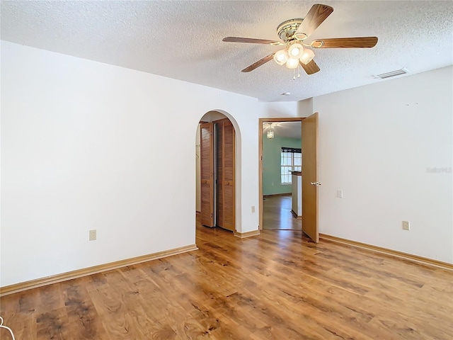 empty room featuring wood-type flooring, a textured ceiling, and ceiling fan