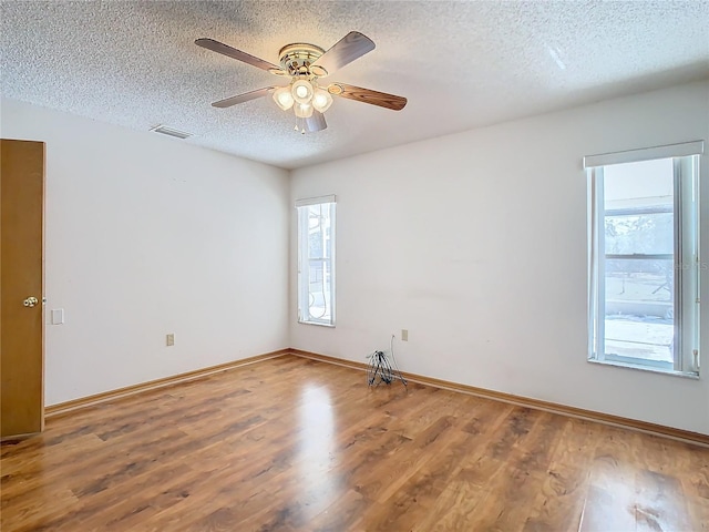 spare room with ceiling fan, hardwood / wood-style floors, and a textured ceiling