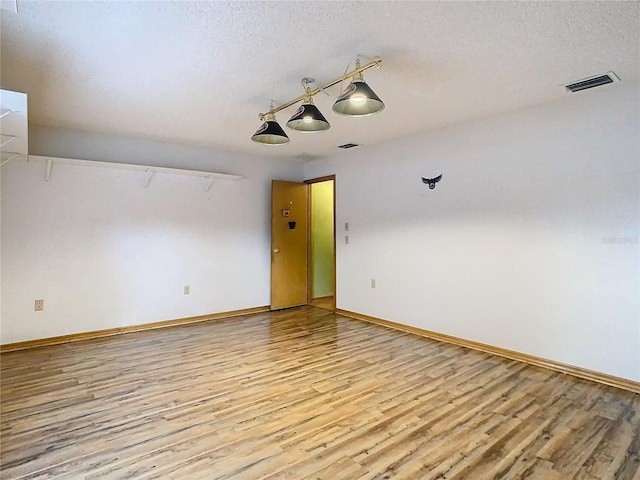 empty room featuring light hardwood / wood-style floors and a textured ceiling