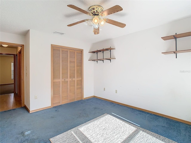 unfurnished bedroom featuring carpet, a textured ceiling, a closet, and ceiling fan