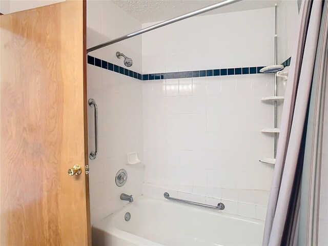 bathroom featuring shower / bath combo with shower curtain and a textured ceiling