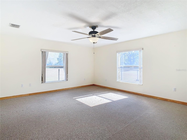 carpeted empty room featuring plenty of natural light and ceiling fan