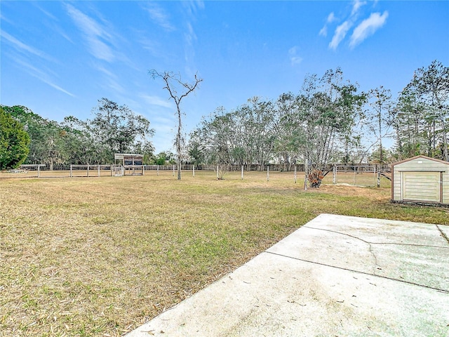 view of yard featuring a rural view, a storage shed, and a patio area