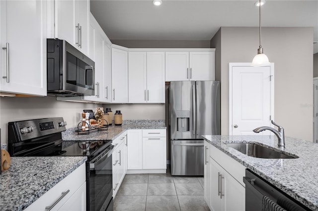 kitchen featuring pendant lighting, white cabinets, sink, light stone countertops, and stainless steel appliances