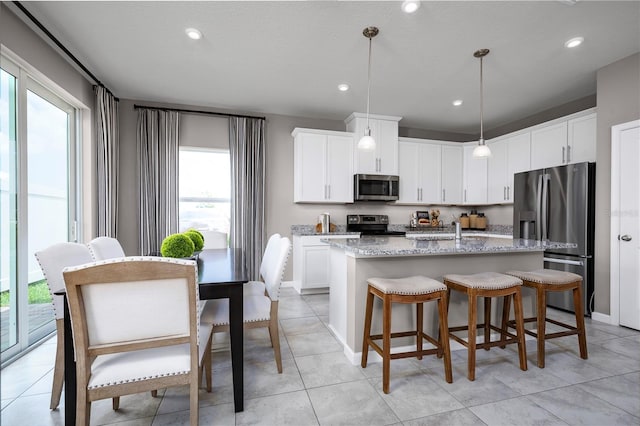 kitchen featuring white cabinetry, a kitchen island with sink, and appliances with stainless steel finishes