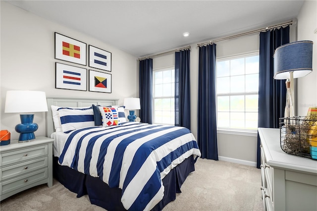 bedroom featuring multiple windows and light carpet