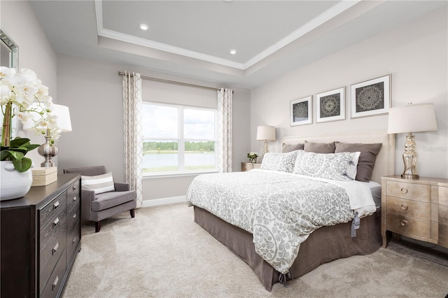 bedroom with light colored carpet, a raised ceiling, and ornamental molding