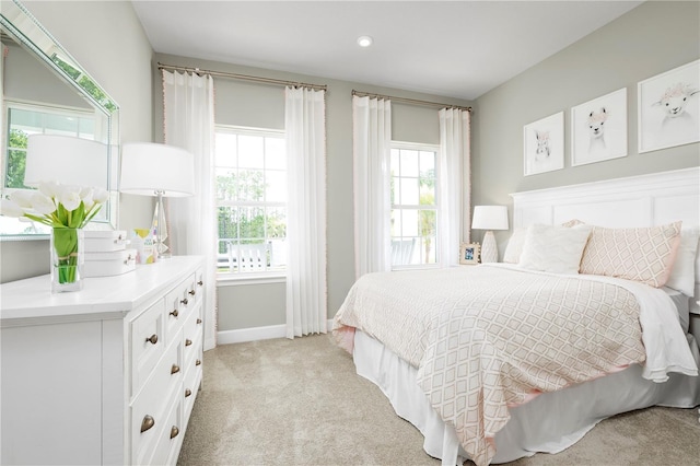 bedroom featuring light carpet and multiple windows