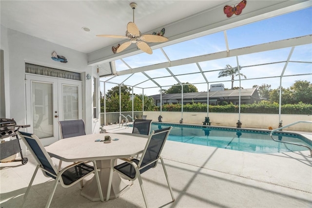 view of swimming pool with glass enclosure, a patio area, french doors, and ceiling fan