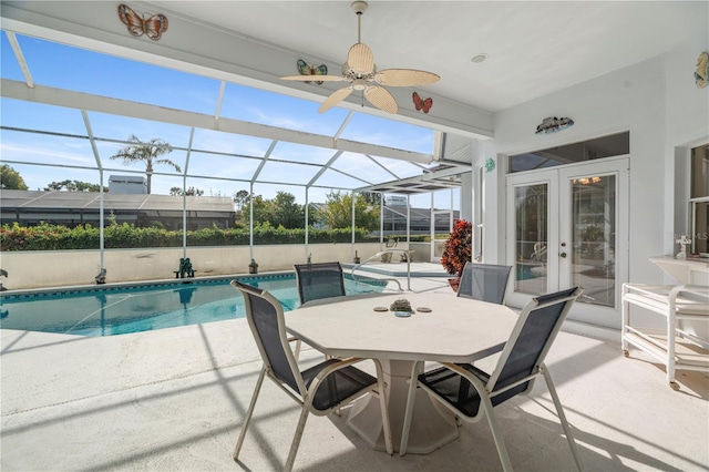 view of swimming pool featuring ceiling fan, a lanai, a patio, and french doors