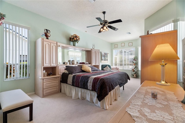 bedroom featuring light carpet, a textured ceiling, and ceiling fan