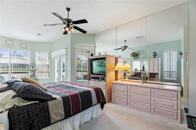 carpeted bedroom with ceiling fan and a textured ceiling