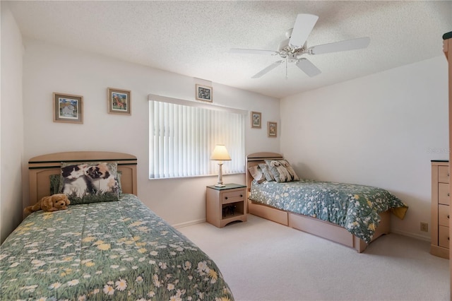 carpeted bedroom featuring ceiling fan and a textured ceiling