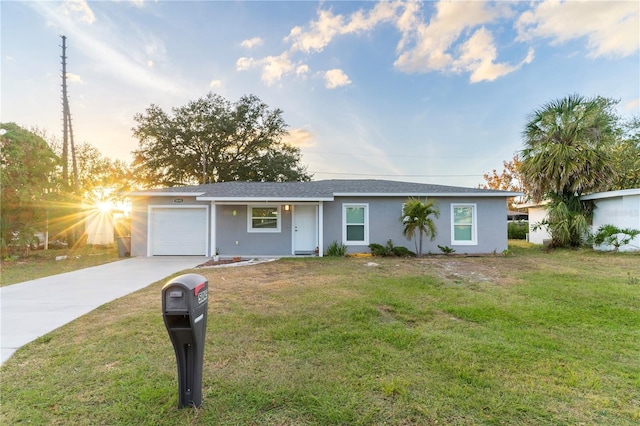 single story home featuring a lawn and a garage