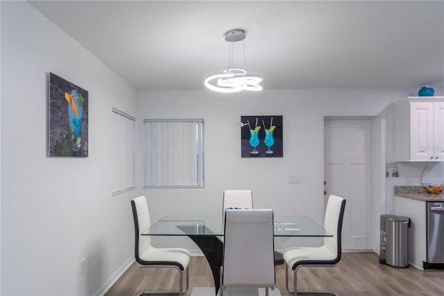 dining area with a chandelier and light hardwood / wood-style flooring