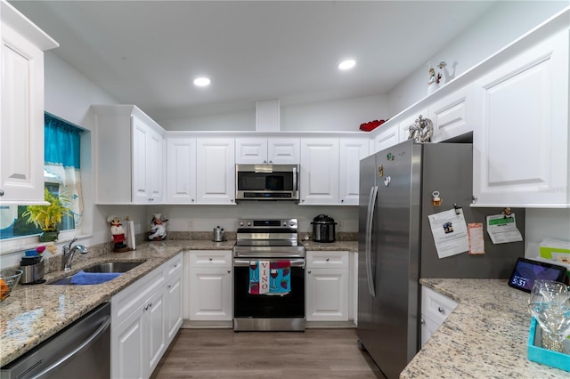 kitchen featuring white cabinets, appliances with stainless steel finishes, and light stone countertops