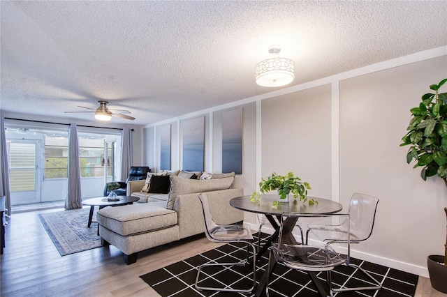 living room with ceiling fan, hardwood / wood-style floors, and a textured ceiling