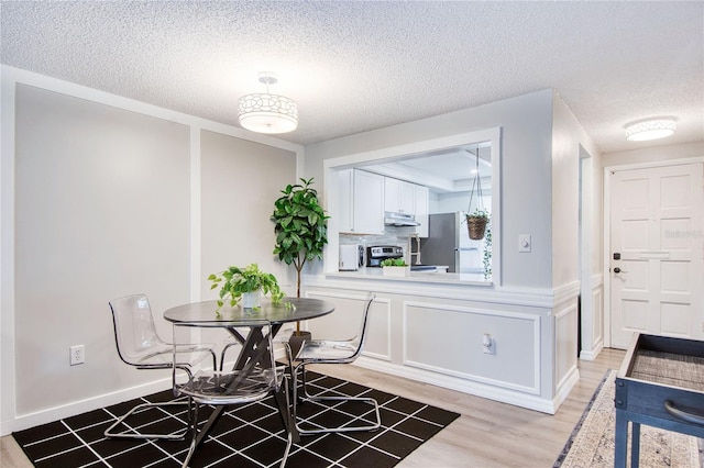 4209 Prince Pl Unit A, New Port Richey, FL 34652 - dining room featuring light wood-type flooring and a textured ceiling