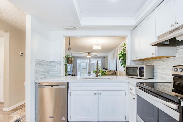 kitchen featuring white cabinets, ceiling fan, stainless steel appliances, and tasteful backsplash