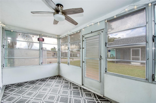 unfurnished sunroom featuring ceiling fan and a wealth of natural light