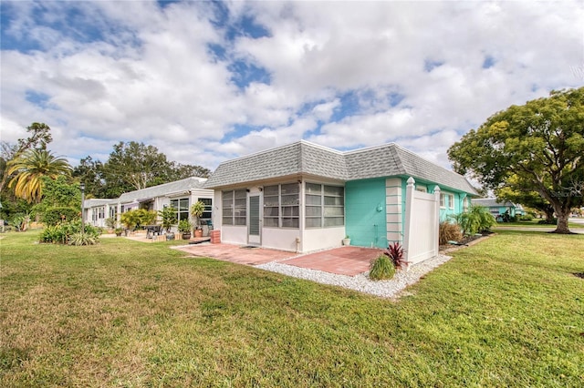 back of property featuring a lawn and a sunroom