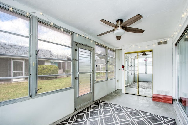 unfurnished sunroom featuring ceiling fan and a healthy amount of sunlight