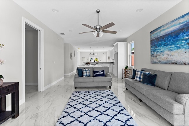 living room featuring ceiling fan with notable chandelier