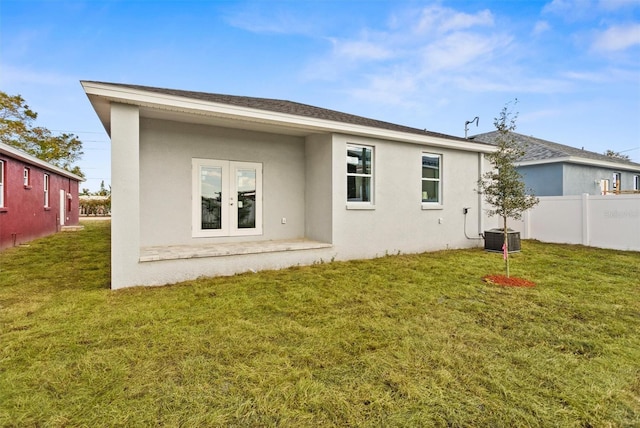 rear view of property featuring french doors and a lawn