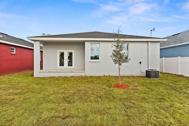 rear view of property with french doors, central AC unit, and a lawn