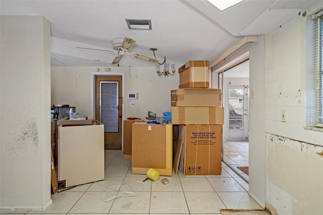 kitchen with ceiling fan, light tile patterned floors, and a textured ceiling