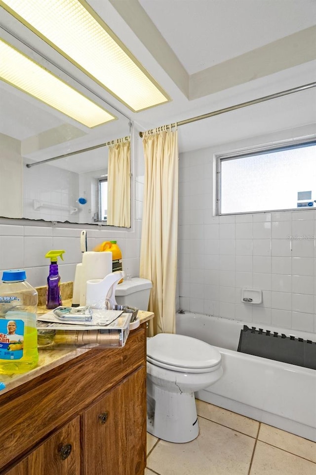 bathroom featuring tile patterned floors, toilet, tile walls, and shower / tub combo with curtain