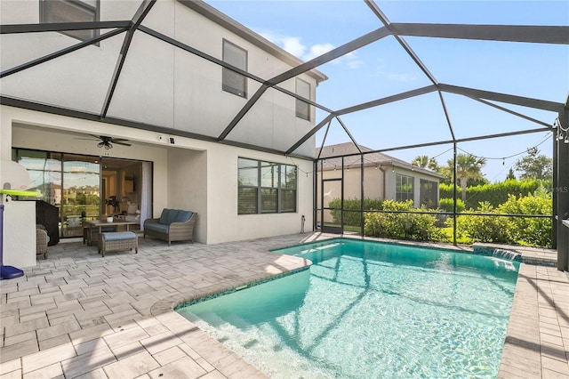 view of swimming pool featuring glass enclosure, an outdoor hangout area, pool water feature, ceiling fan, and a patio area