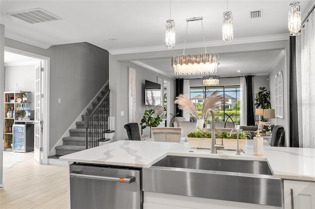 kitchen featuring light stone countertops, crown molding, sink, a notable chandelier, and dishwasher