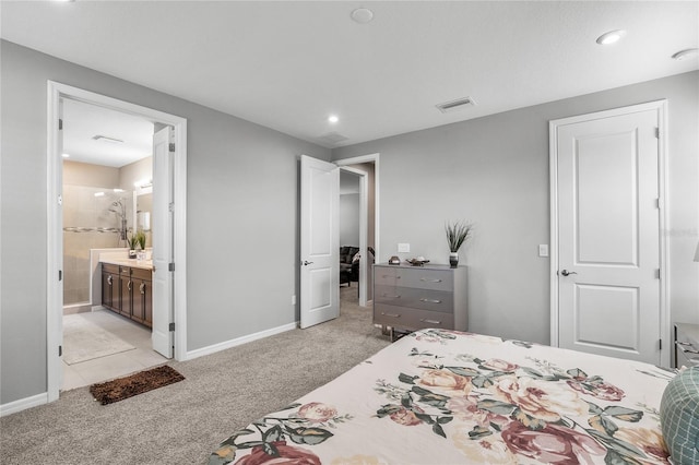 bedroom with connected bathroom and light carpet