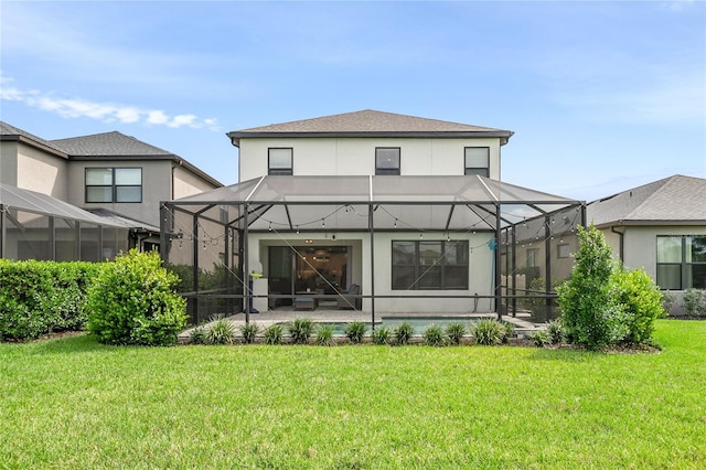 rear view of property featuring glass enclosure, a yard, and a patio