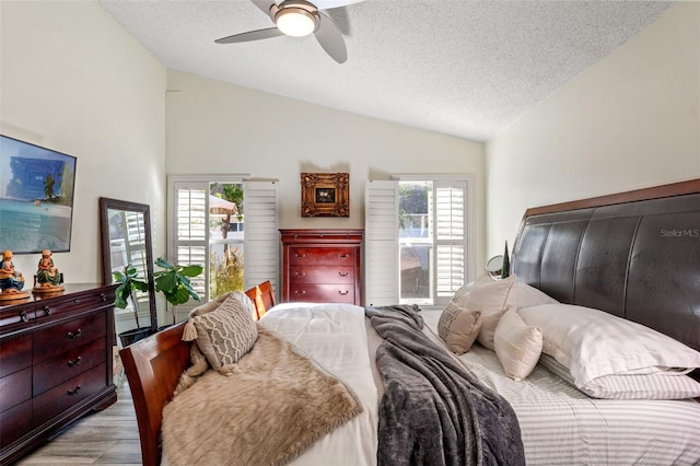 bedroom with multiple windows, a textured ceiling, ceiling fan, and lofted ceiling