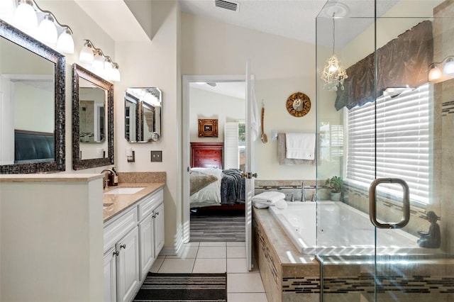 bathroom with tile patterned floors, vanity, a relaxing tiled tub, and vaulted ceiling