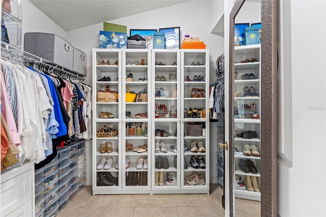 walk in closet with light tile patterned flooring and vaulted ceiling