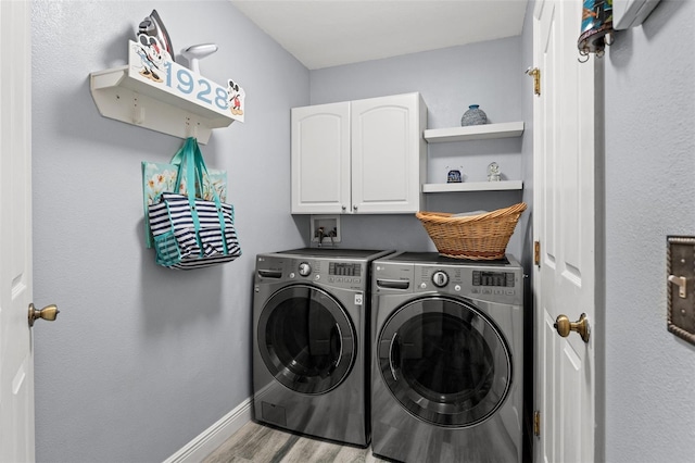 laundry room with washer and dryer, cabinets, and light hardwood / wood-style flooring